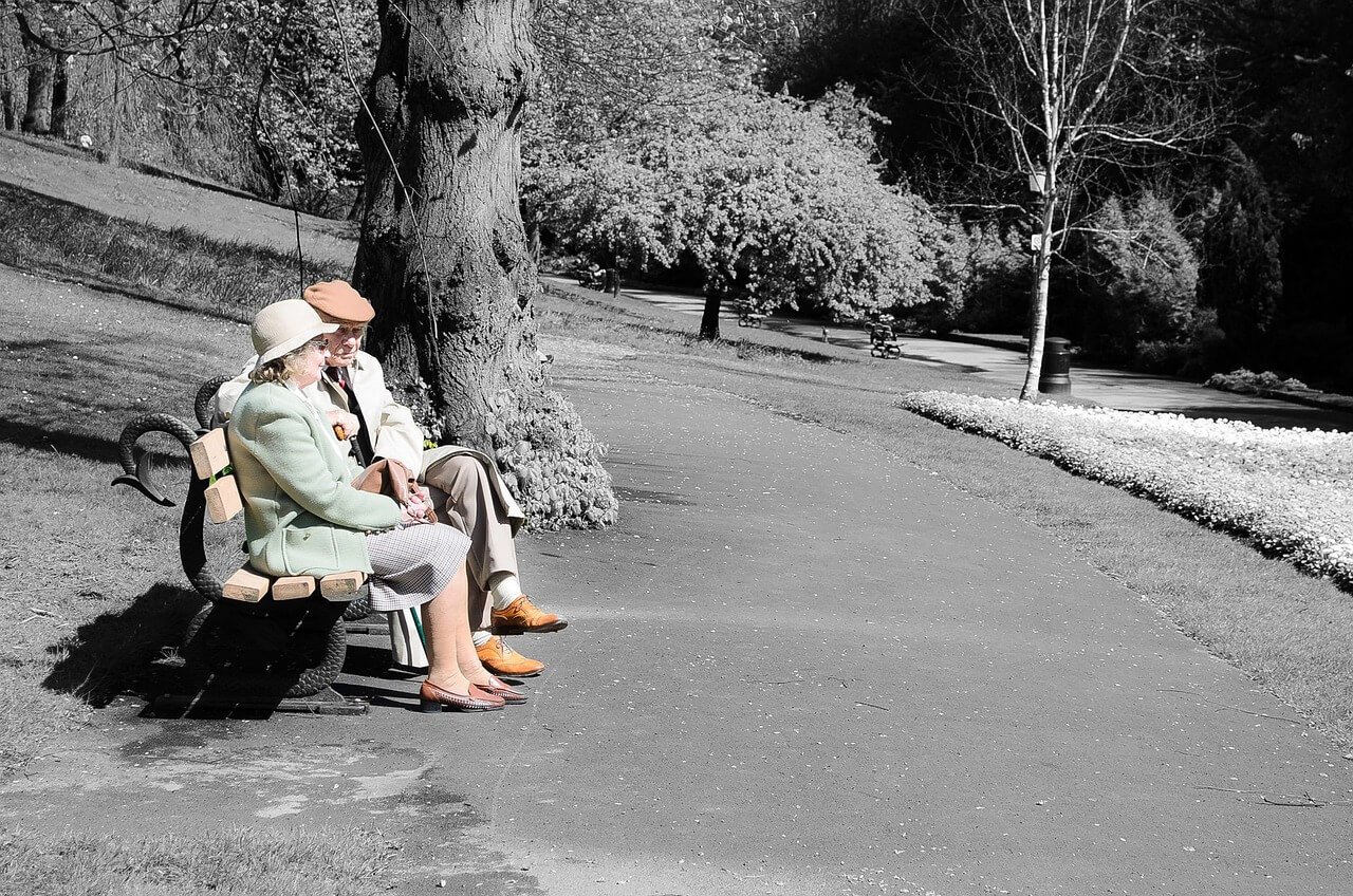 Elderly couple sitting on a park bench